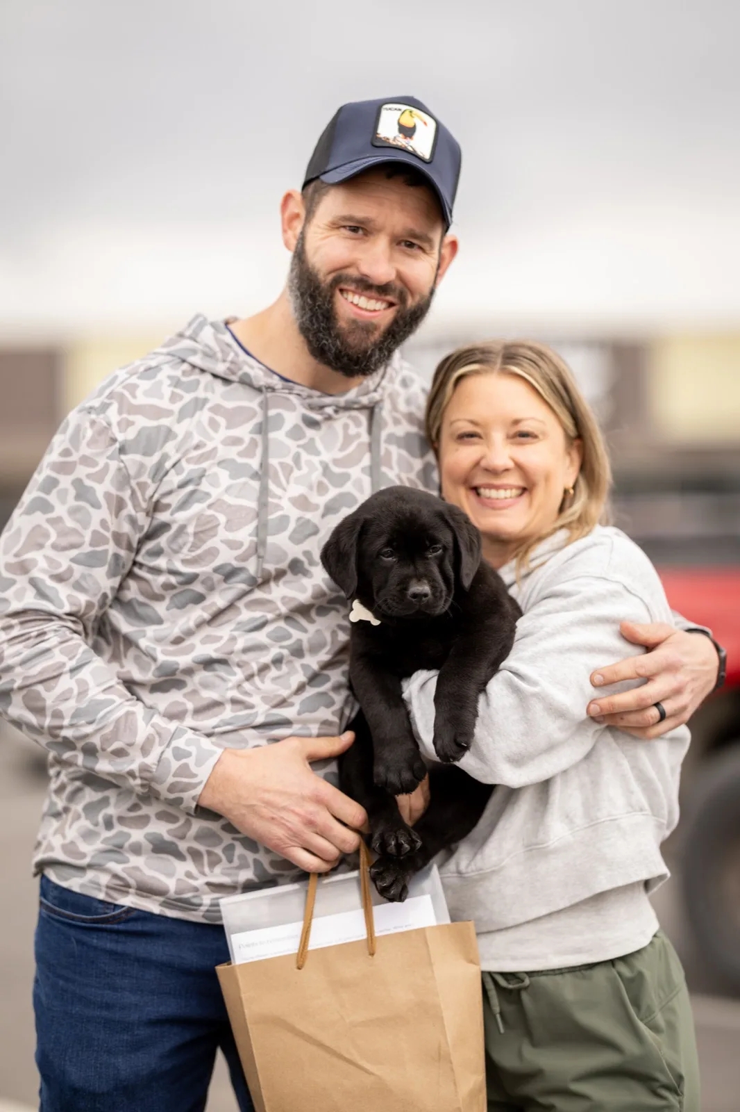 A family meeting their new Happiest Labrador puppy on gotcha day