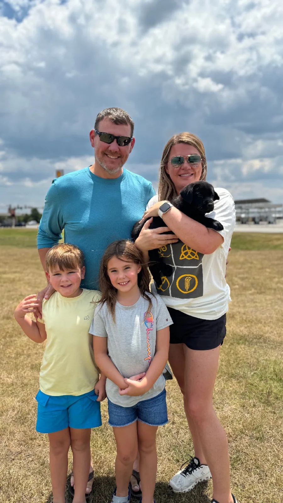 A family meeting their new Happiest Labrador puppy on gotcha day