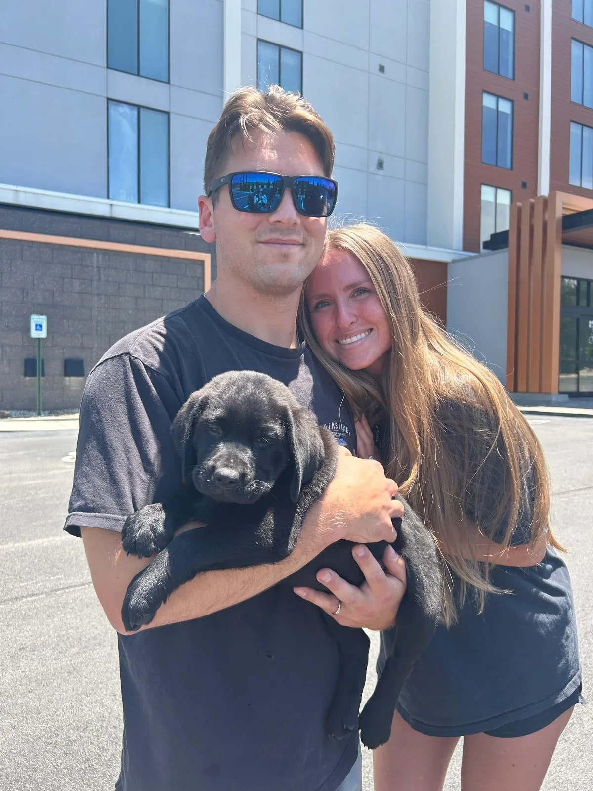 A family meeting their new Happiest Labrador puppy on gotcha day