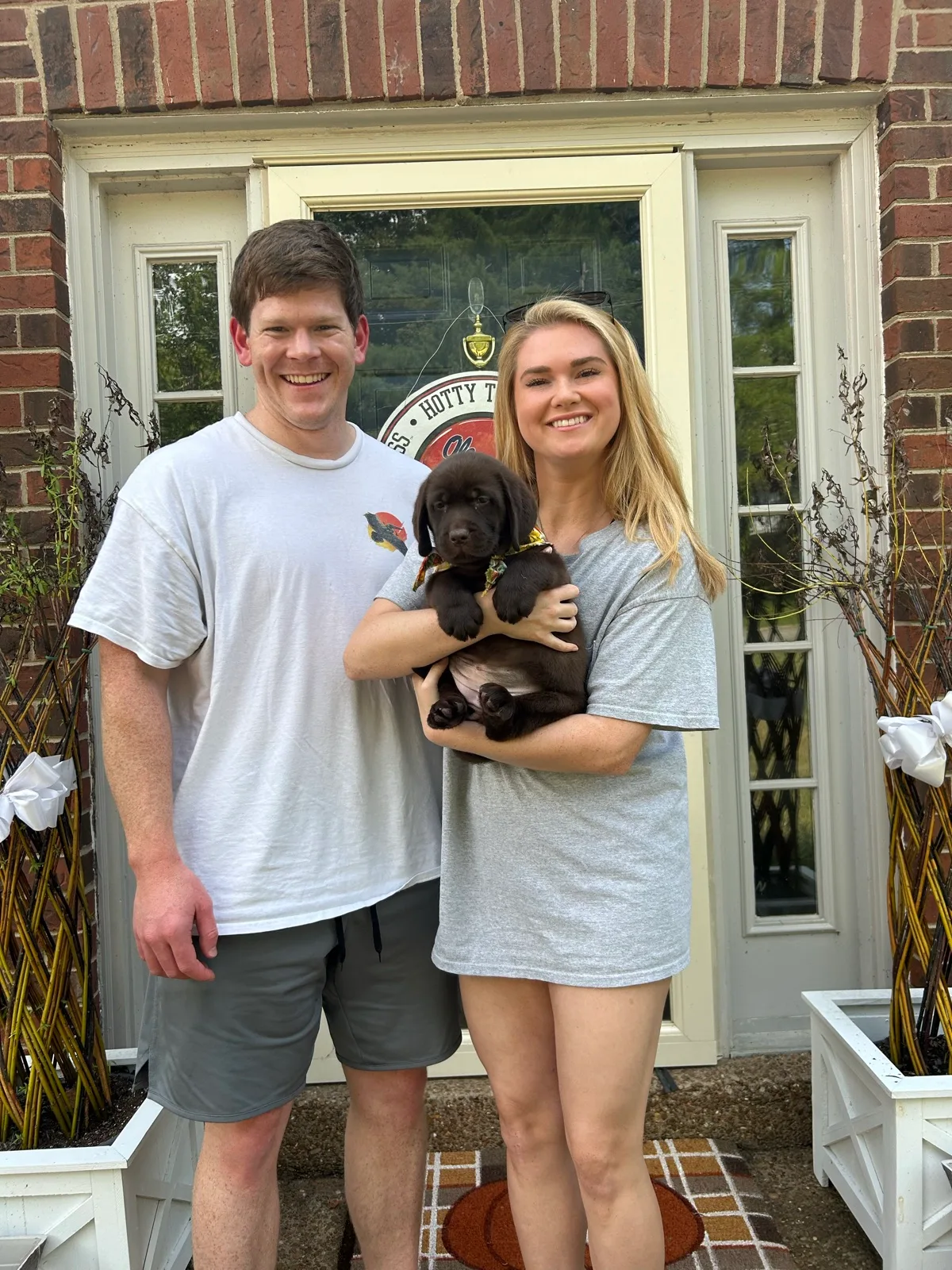 A family meeting their new Happiest Labrador puppy on gotcha day